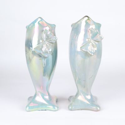 two vases that are sitting side by side on a white surface