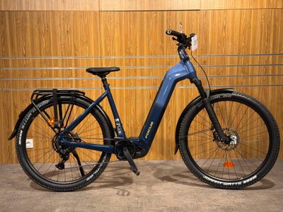 un vélo électrique bleu garé devant un mur en bois