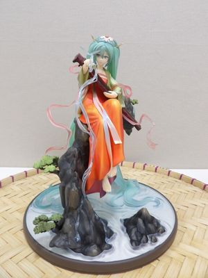 figurine d'anime représentant une femme assise sur un rocher