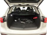 the back of a white car with a trunk full of wires