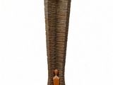 a wooden sculpture of a person standing in a tall vase
