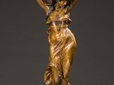 an antique bronze statue of a woman carrying a pot on her head