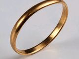 gros plan d'une bague en or sur une surface blanche