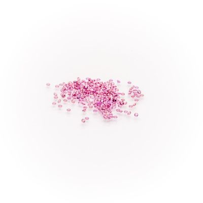 a pile of pink crystals sitting on top of a white surface
