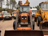a tractor that is parked in a lot with other vehicles behind it