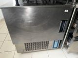 a stainless steel refrigerator in the middle of a tiled floor
