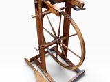 an old spinning machine with wooden wheels on a white surface