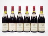 six bouteilles de vin sont alignées sur une surface blanche