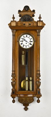 a wooden clock hanging on the wall with a clock on it