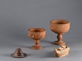 trois pièces de poterie posées les unes à côté des autres sur une table