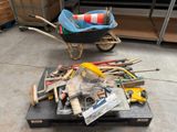 une brouette pleine d'outils et des outils par terre