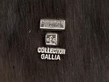 silver plate with a black background and a white and black logo on it