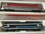 two model trains sitting in a box on a table