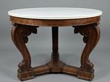 une table à plateau rond en marbre reposant sur un piètement en bois