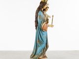 an image of a statue of the virgin mary holding a cross