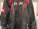une veste de moto noire et rouge suspendue à un cintre dans une pièce
