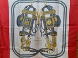 a close up of a red and white scarf with a gold and blue design on it