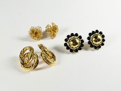 trois paires de boucles d'oreilles dorées et noires sur un fond blanc