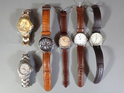 many different types of watches displayed on a table
