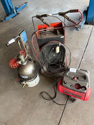 two air compressors on the ground next to a machine