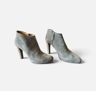 une paire de bottines en daim gris sur fond blanc