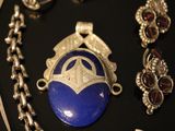 a necklace with a blue stone surrounded by other jewelry