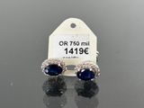 a pair of sapphire and diamond earrings on a black surface
