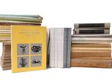 several books are stacked on top of each other on a white surface