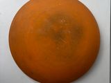 an orange frisbee hanging on the wall next to a white wall