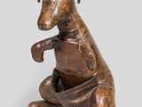 statue en bronze représentant un chien assis sur ses pattes arrière