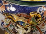 a large blue and yellow vase with a bird on it