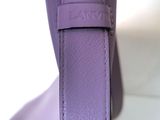 a close up of a purple handbag with a metal handle