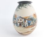 a vase with a painting on it on a white surface