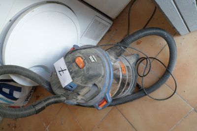 a vacuum that is sitting on the floor next to a dishwasher