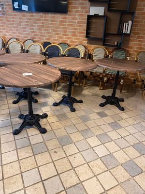 tables and chairs in a room with a brick wall and a television