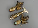trois broches en forme de poisson posées sur une table