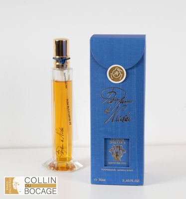 un flacon de parfum posé sur une table, à côté d'une boîte bleue
