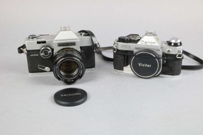 two cameras sitting next to each other on a table