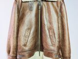 une veste en cuir marron suspendue à un cintre sur un mur blanc