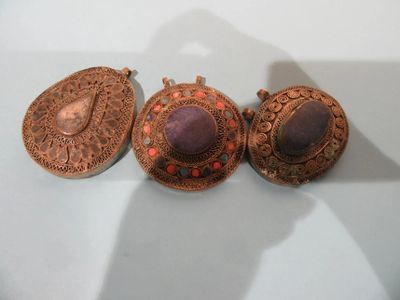 trois bijoux posés sur une table blanche