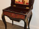 a small wooden desk with a mirror on top of it