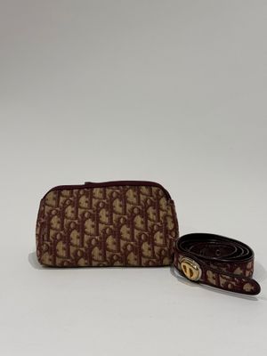 a brown and white purse with a belt on a white surface