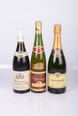 three bottles of wine are lined up on a white surface