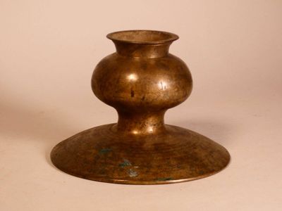 a bronze vase that is sitting on a table