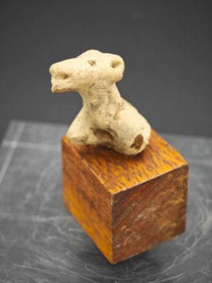 sculpture représentant un chien assis sur un bloc de bois posé sur une table