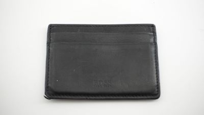 un portefeuille en cuir noir posé sur une table blanche