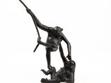 statue of a monkey holding a branch on a rock
