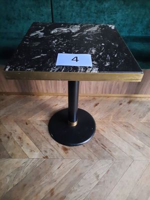 une petite table sur laquelle est inscrit un chiffre, posée sur un parquet