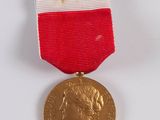 a gold medal with a red, white, and blue ribbon around it