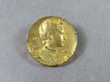 a close up of a gold coin with a woman ' s face on it
